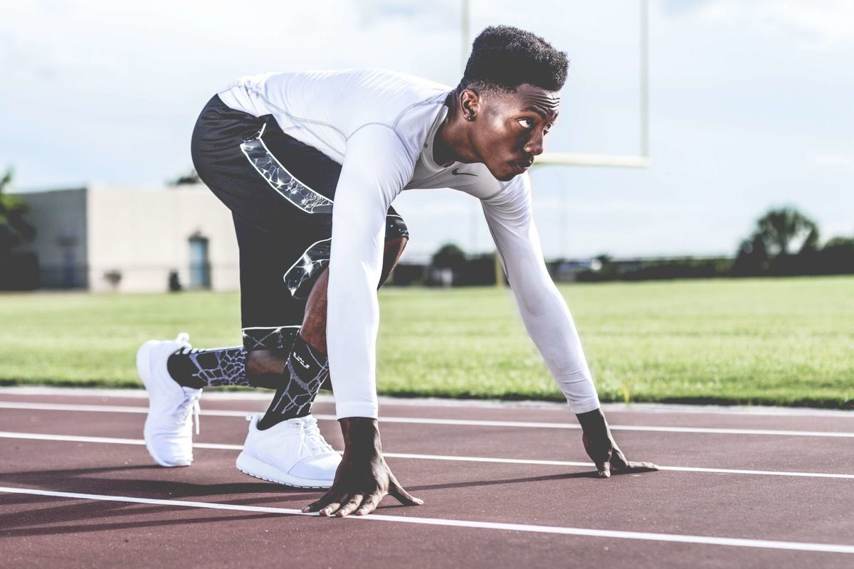 Sprinter en position de départ sur piste d'athlétisme