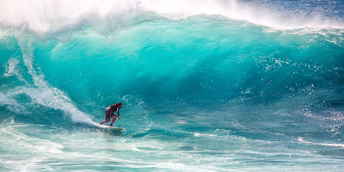 Surfeur dans une vague turquoise